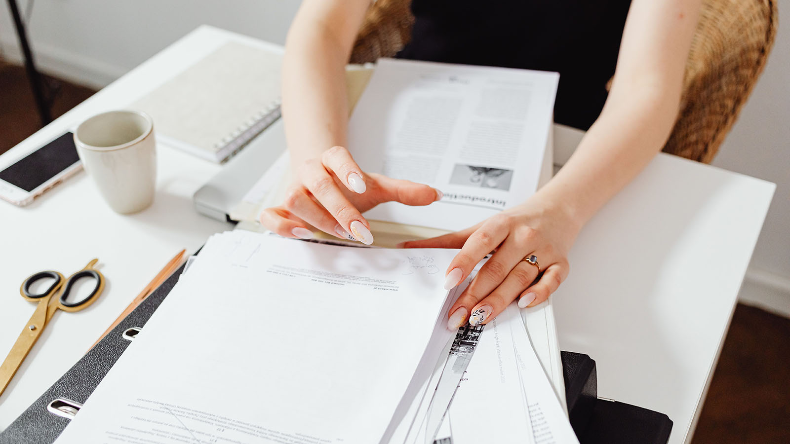A person sorting important letters and paperwork at a desk