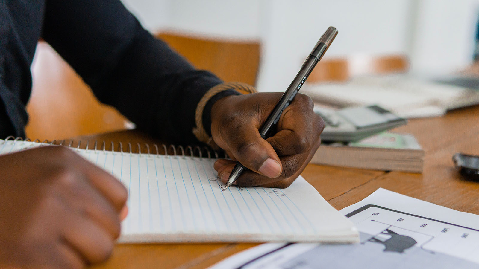 Close-up of a person writing a personal tribute in a notebook