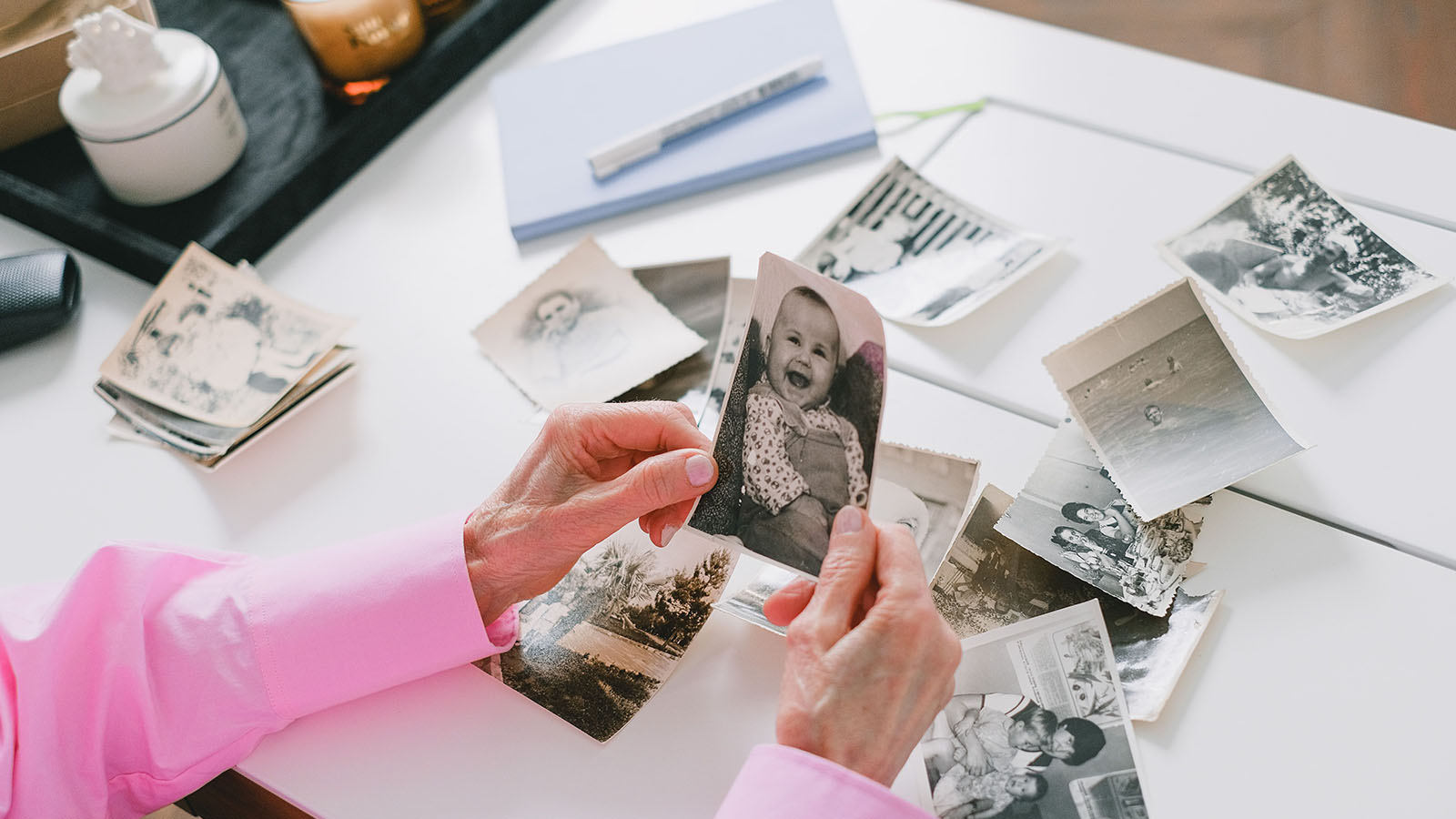 A person sorting old family photographs on a table