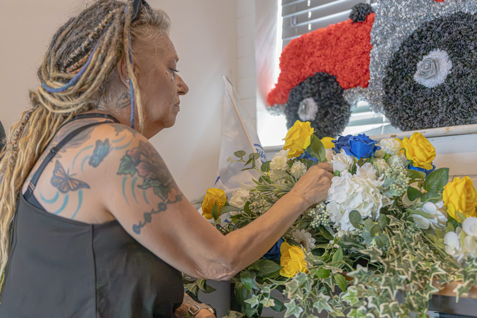 A seasonal floral tribute being arranged by hand